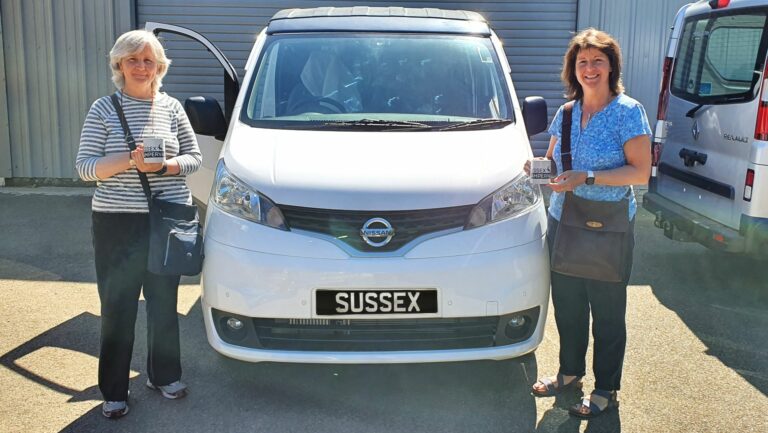 2 ladies standing beside a campervan